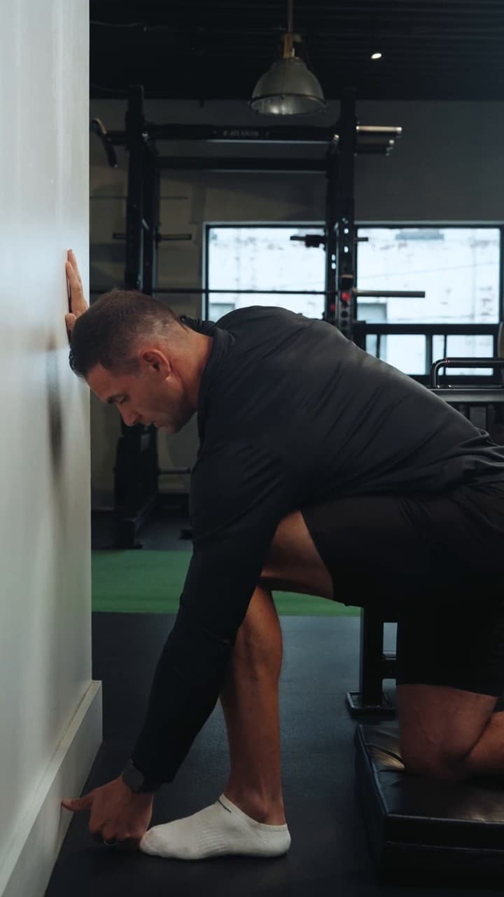 Ankle mobility screen performed with the knee driving toward a wall